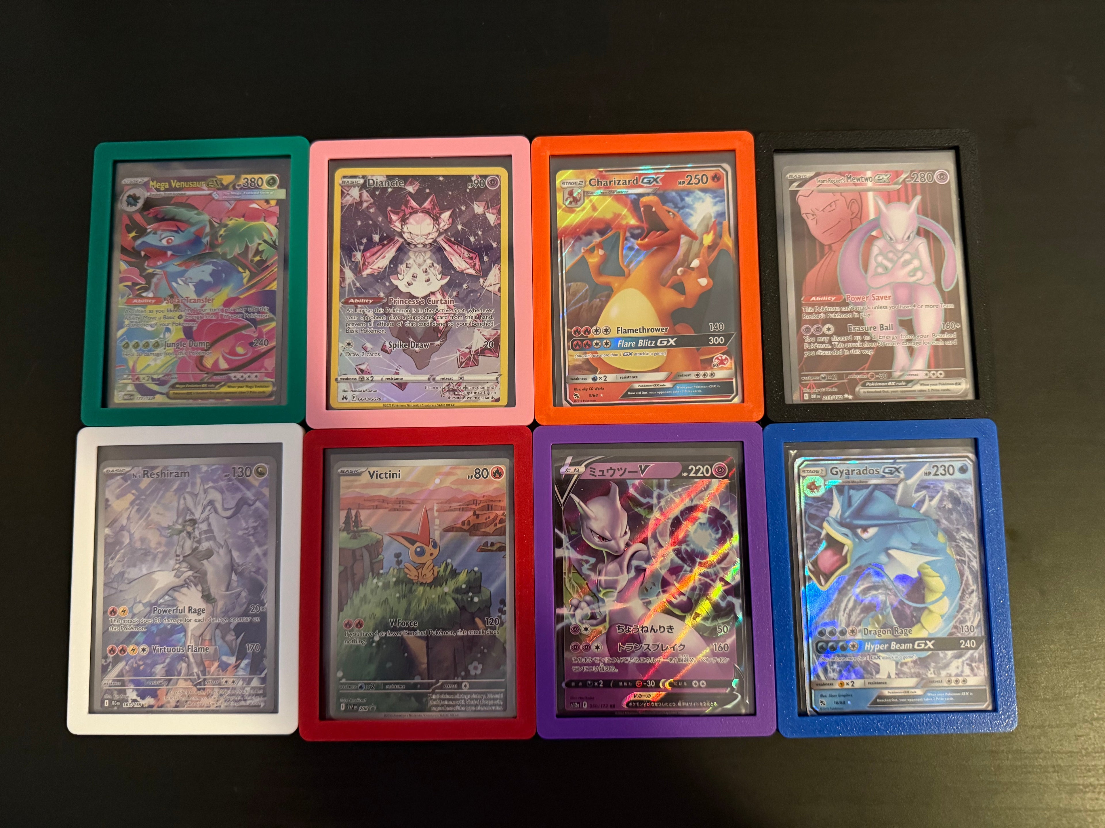 Collection of colorful trading cards in protective sleeves on a dark surface