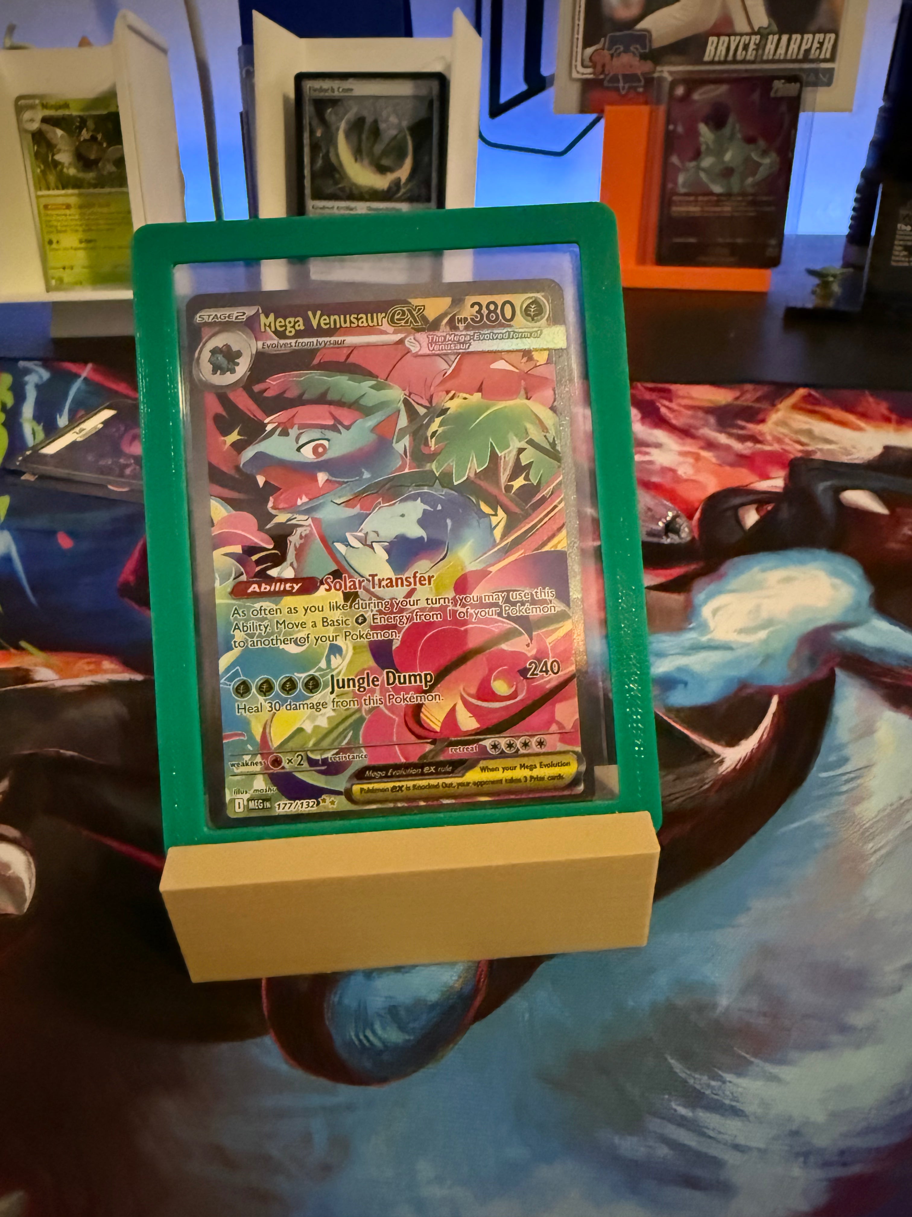 Trading card in a holder on a colorful surface with other cards in the background